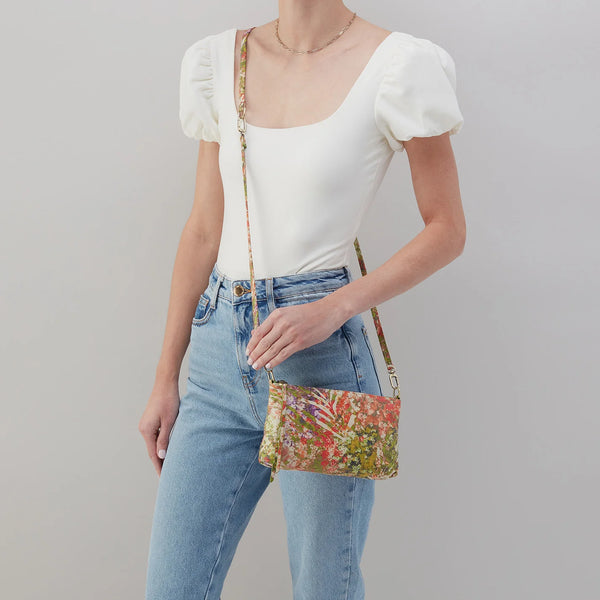 Model Wearing HOBO Darcy as a Crossbody in Tropic Floral Printed Leather with Single Leather strap in the Longest Configuration.